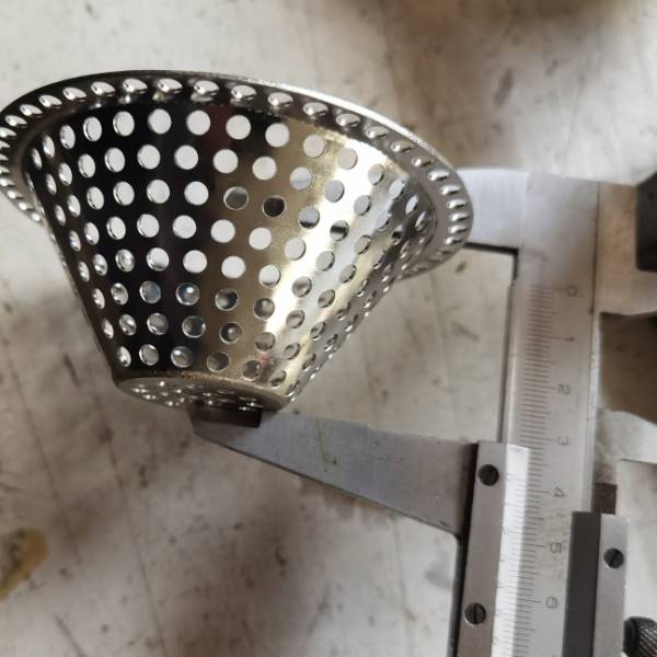 A caliper is used to check the overall height of the bowl-shape perforated filter.