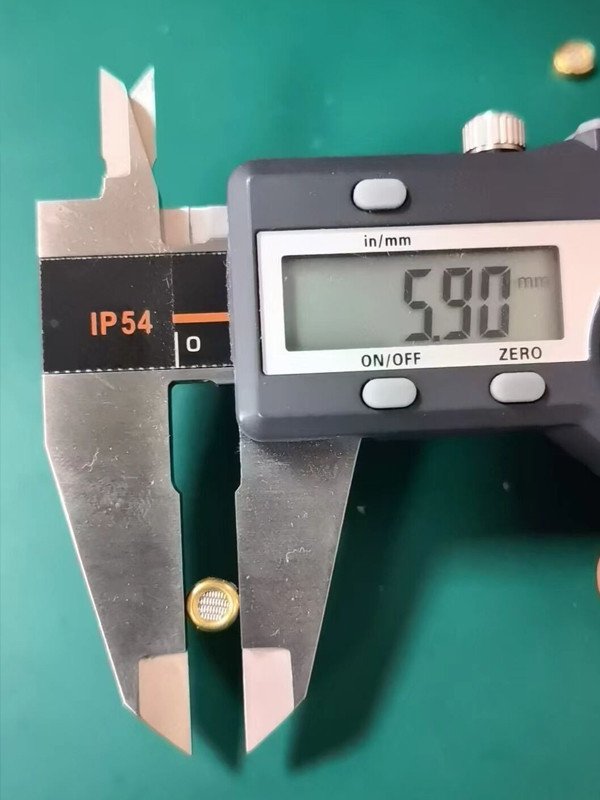 Vernier caliper is measuring the diameter of the brass filter border.