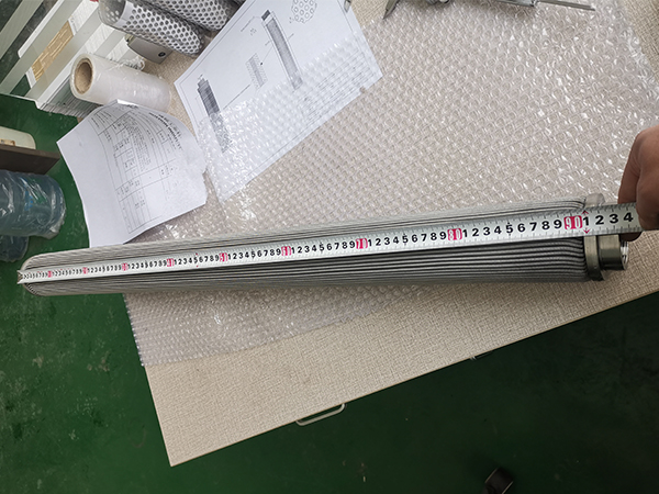 A worker is measuring the length of polymer melt filter element.