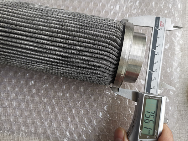 A worker is measuring the outside diameter of polymer melt filter element and it shows 75.61 mm.