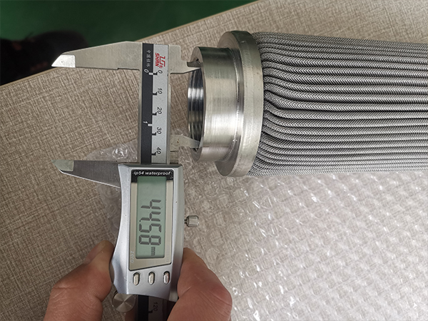 A worker is measuring the thread inner diameter of polymer melt filter element and it shows 44.58 mm.