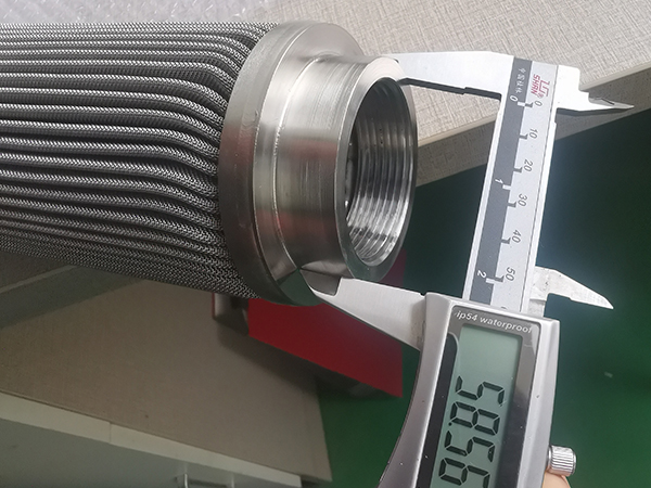 A worker is measuring the thread outer diameter of polymer melt filter element and it shows 58.56 mm.