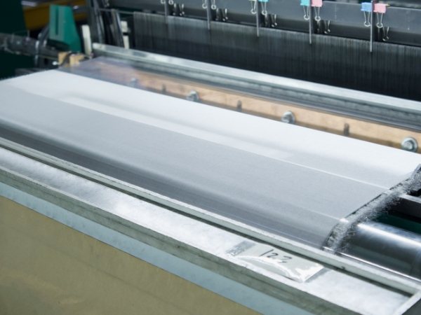 The weaving machine is weaving the metal wires into woven mesh.