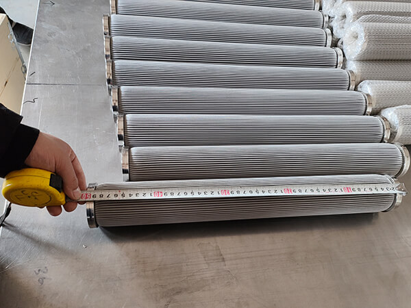 A worker measures one of the multiple filter elements length with a metric ruler
