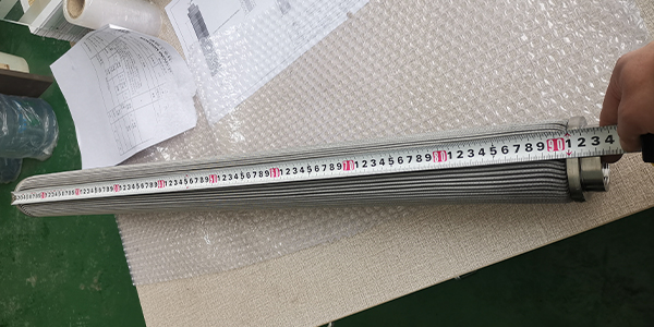 Un trabajador está midiendo la longitud del elemento de filtro de fusión de polímero.